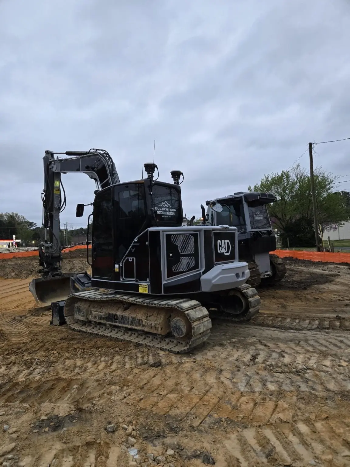Culbertson-branded excavator and dozer on a prepared construction site.