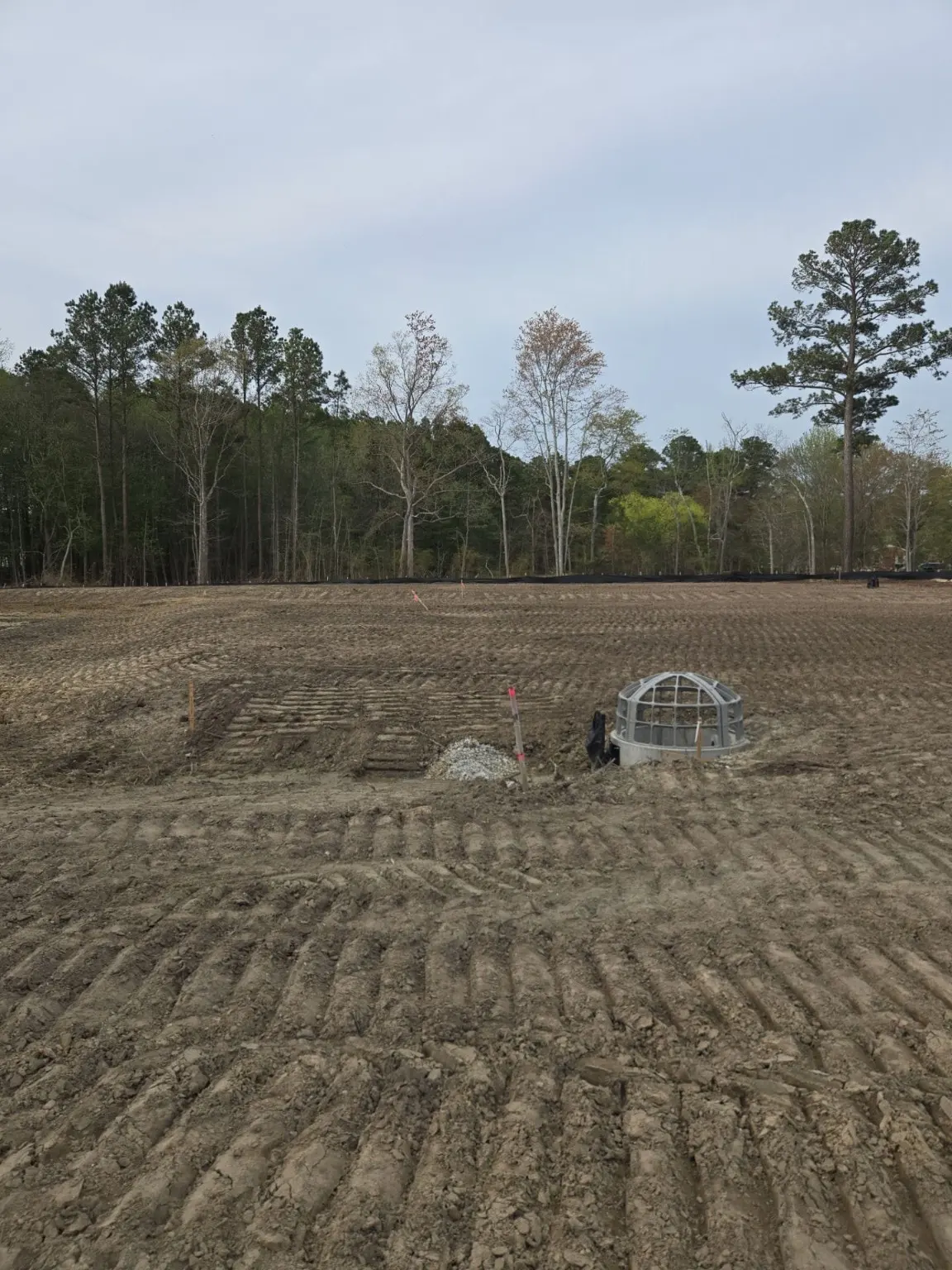 A grated stormwater structure within a graded site.